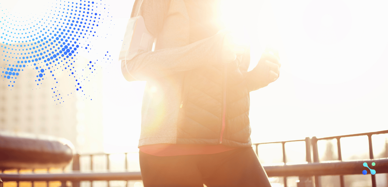 Person jogging in sunlight with fitness armband, symbolizing the positive social impact of investing in fintech for global good.